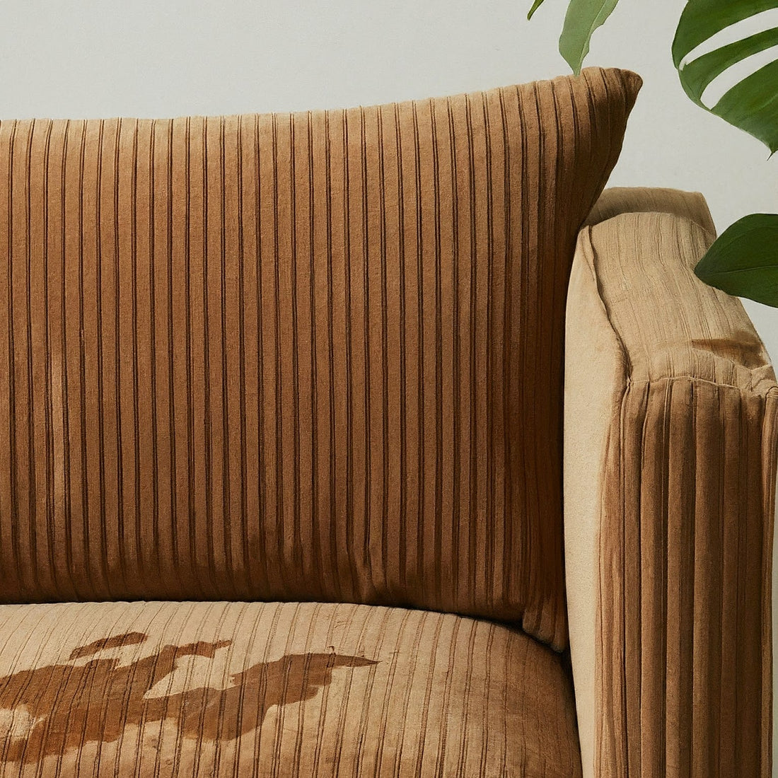 Brown corduroy couch with visible stain
